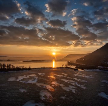 Captivating sunset at Minneiska, MN with a frozen Mississippi River reflecting the golden sky.