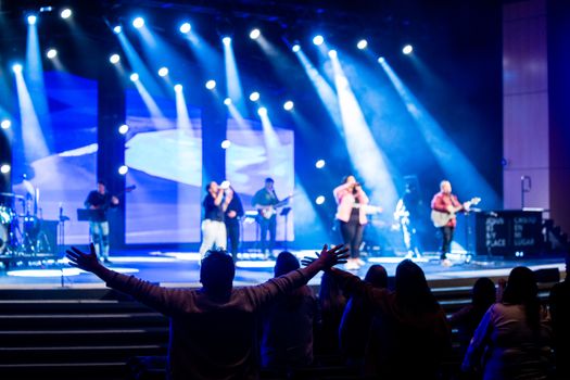A dynamic live concert with a band on stage and an engaging audience, featuring vibrant lighting.