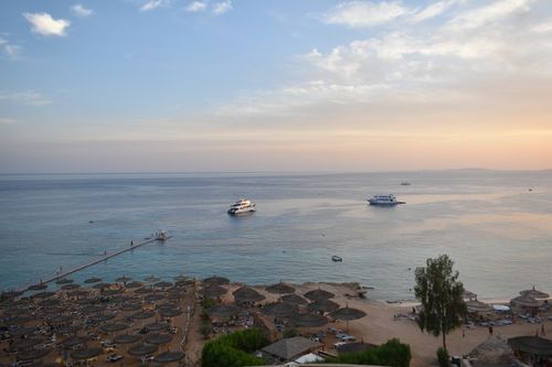 Free Stunning aerial view of Sharm El Sheikh's beach and sea during sunset with boats and parasols. Stock Photo