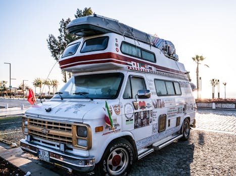 Retro camper van with decorations, parked in a sunny urban area, showcasing adventure vibes.