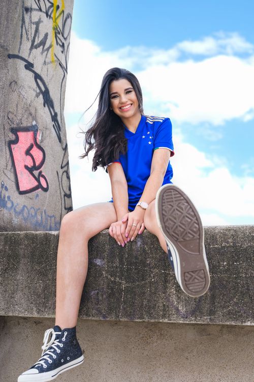 Free A stylish woman smiling and posing with graffiti and blue sky backdrop. Stock Photo
