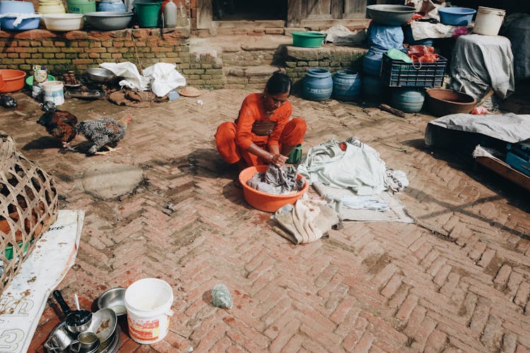 Woman Washing Clothes In Washbasin Outdoors