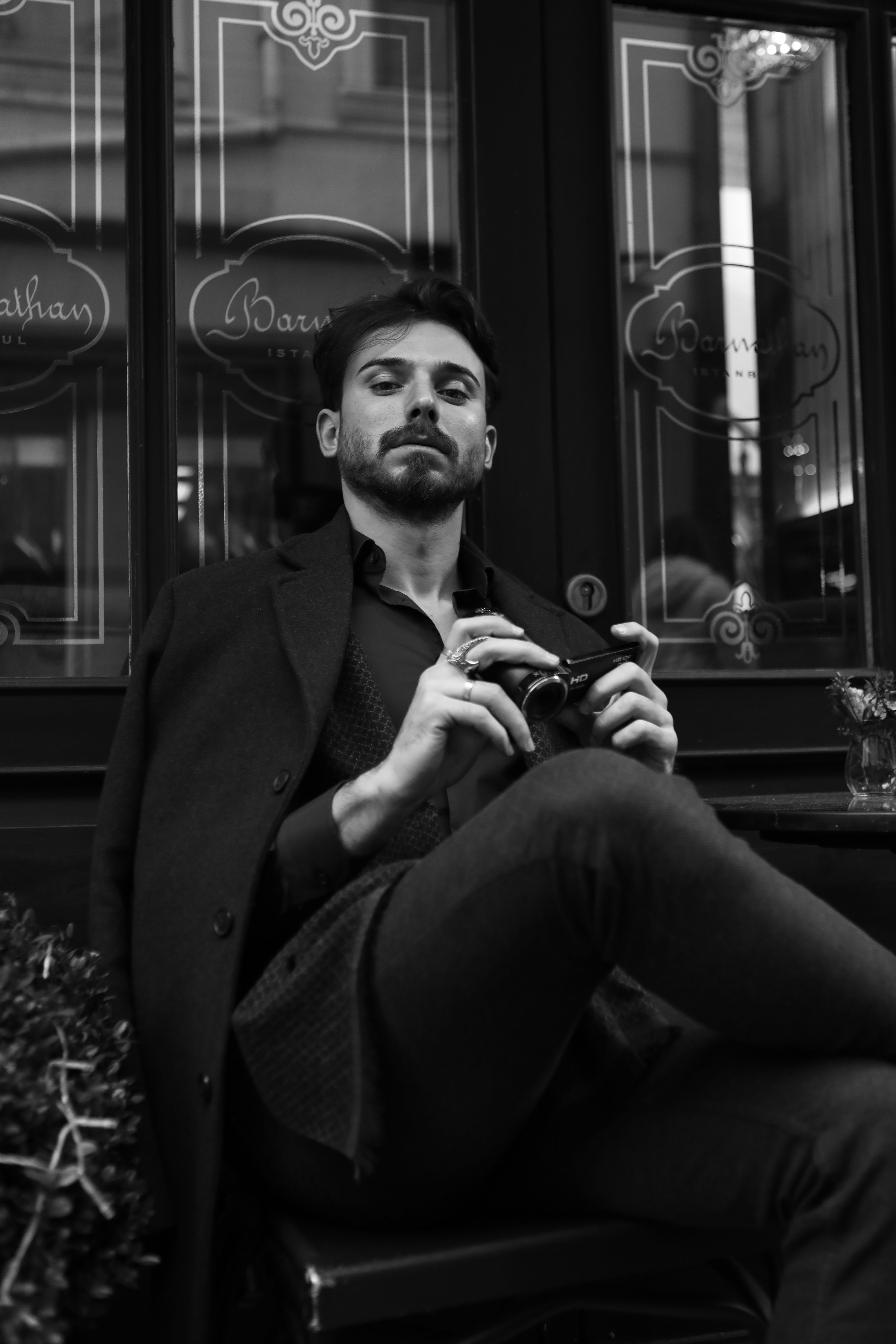 good looking man in a suit sitting with a camera in his hands