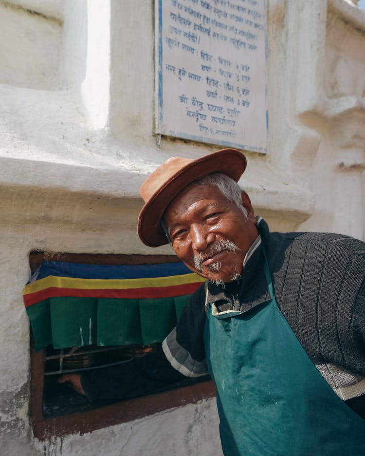 Elderly Man Putting Hand In Hole In The Wall