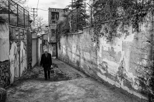 Man Walking Street Between Walls