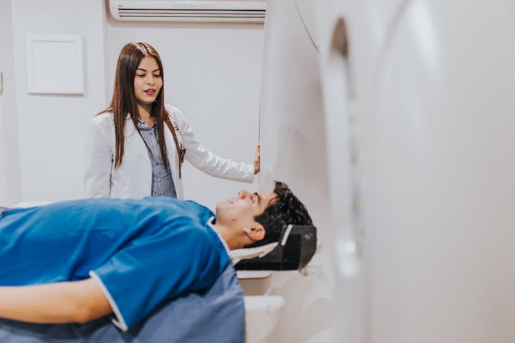 Doctor With Patient Near MRI Machine In Hospital