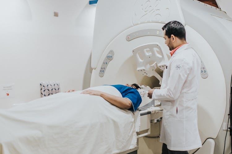 Doctor Examining Patient On MRI Machine