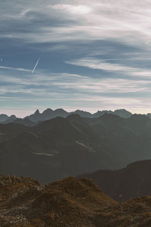 Free A breathtaking view of a foggy mountain range under a misty evening sky. Stock Photo