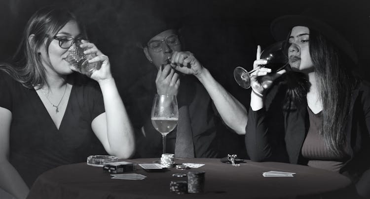 People Sitting At Table Playing Poker Drinking Wine