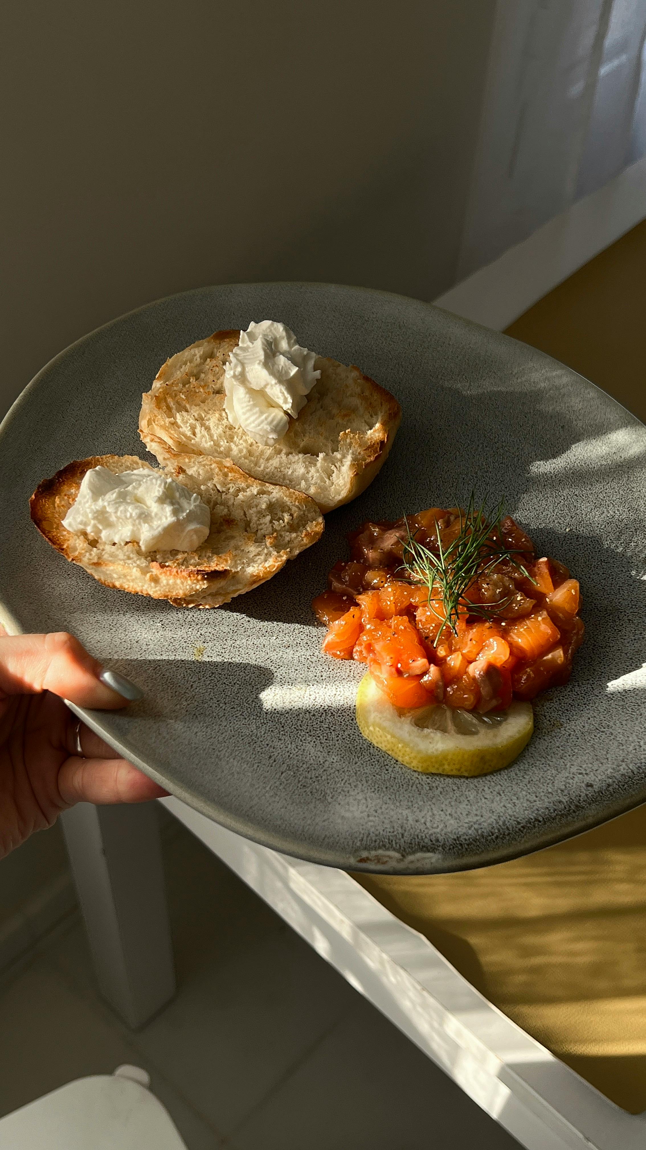 Delicious breakfast plate featuring bread with cream cheese and salmon tartare.