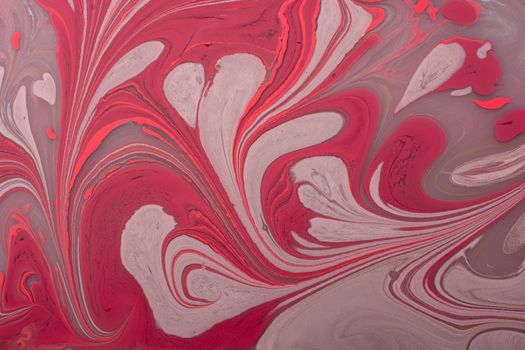 Vibrant red and beige swirling marble pattern creating an abstract art piece.