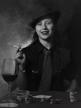 A stylish woman in vintage attire smokes and holds cards at a casino table.