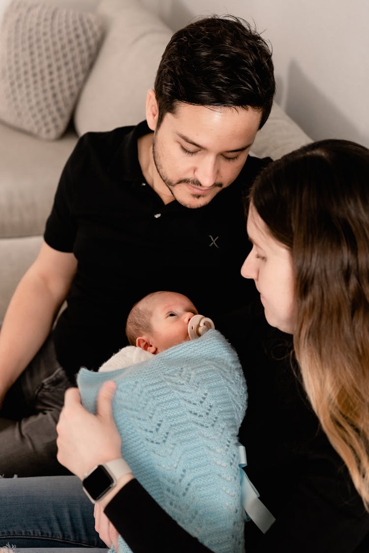 Young Parents Holding Their Newborn Baby 