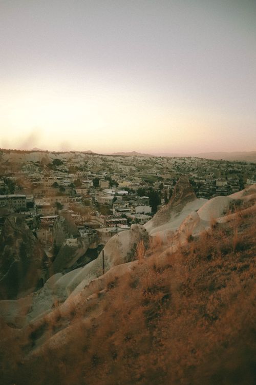 Free A breathtaking sunset view of Göreme town in Cappadocia, Türkiye, showcasing unique geological formations. Stock Photo