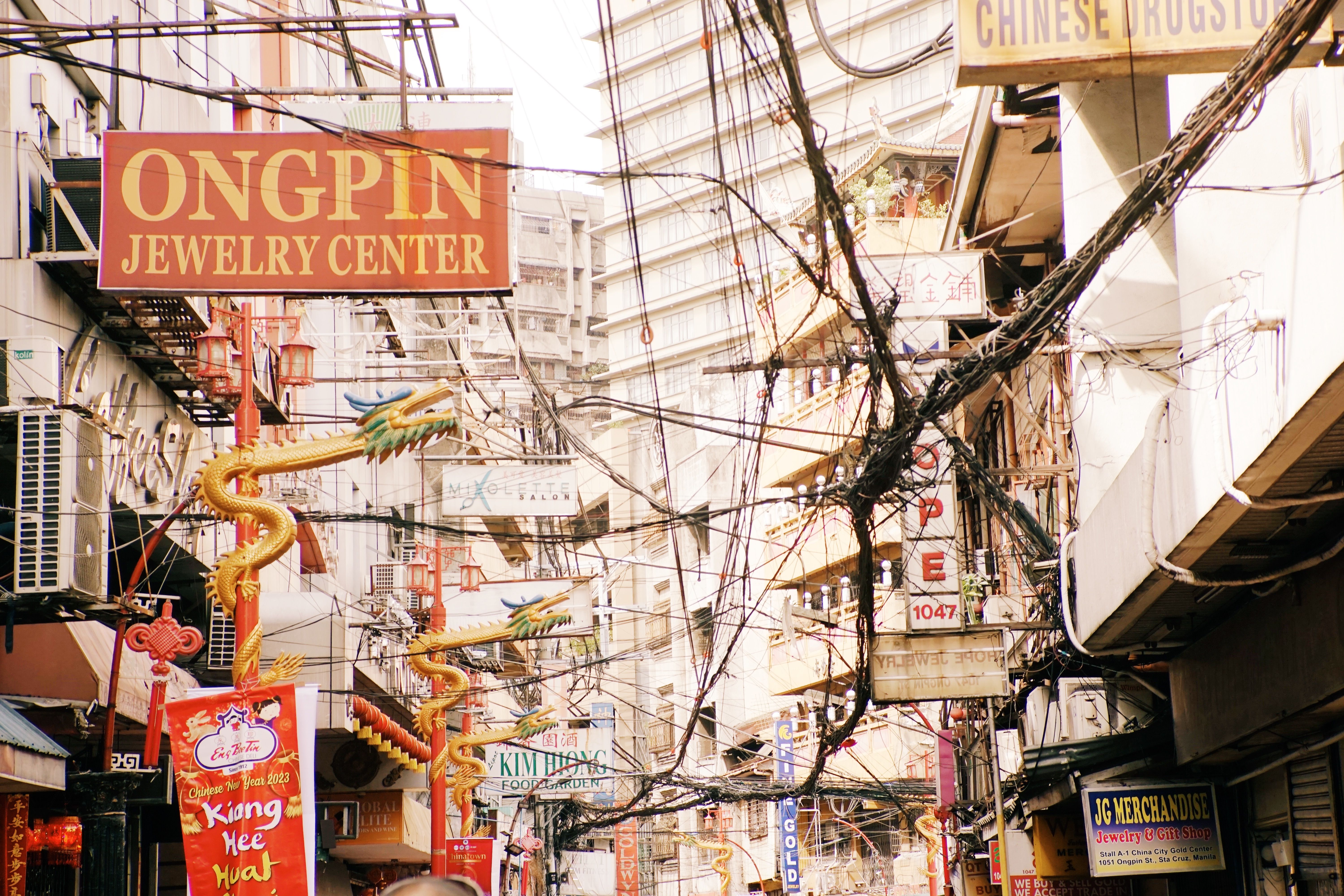 Colorful urban scene in Chinatown with signage and electrical cables in bustling city street.