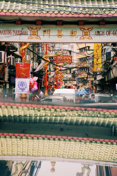 Free Vibrant scene of a busy Chinatown street with an iconic archway, bustling crowd, and colorful decorations. Stock Photo