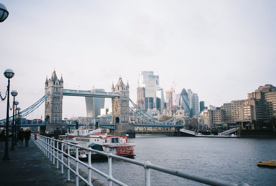 Tower Bridge with London's modern skyline and boats on the Thames River.