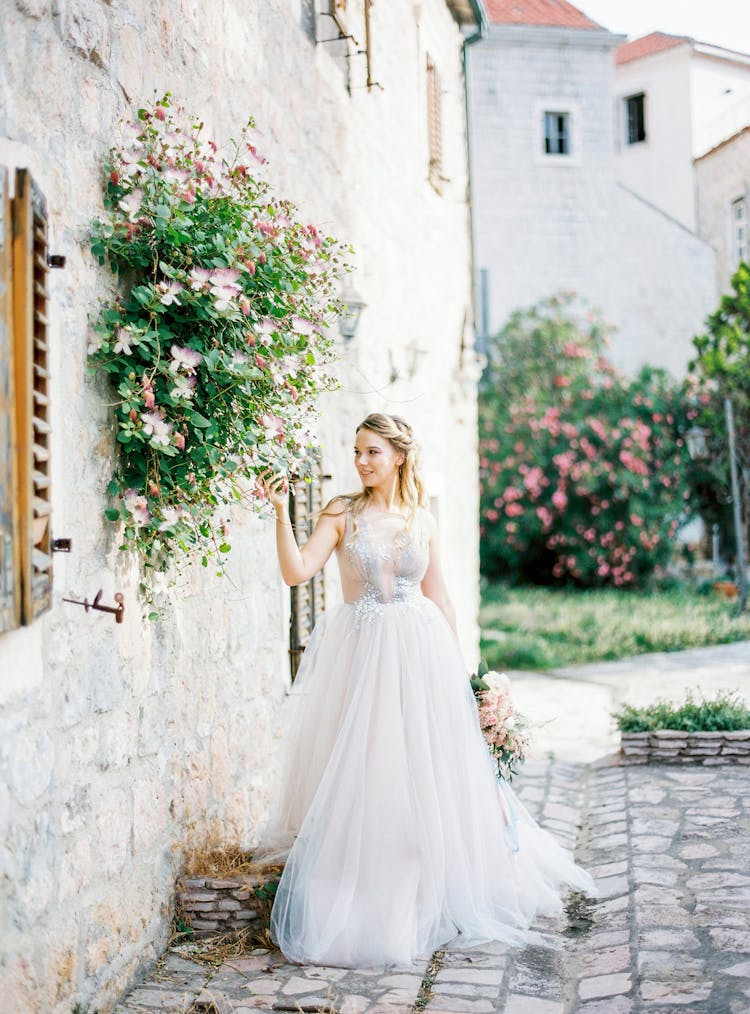 Bride In Elegant Wedding Dress Posing Near Old Castle