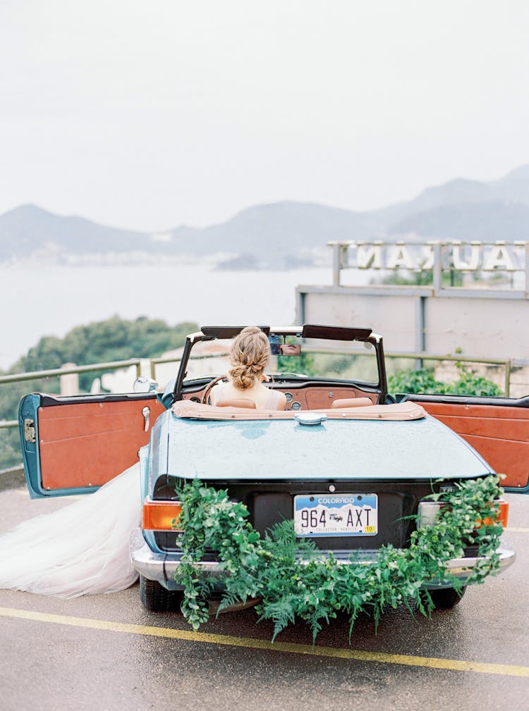 Bride Sitting In Retro Car At Wedding 