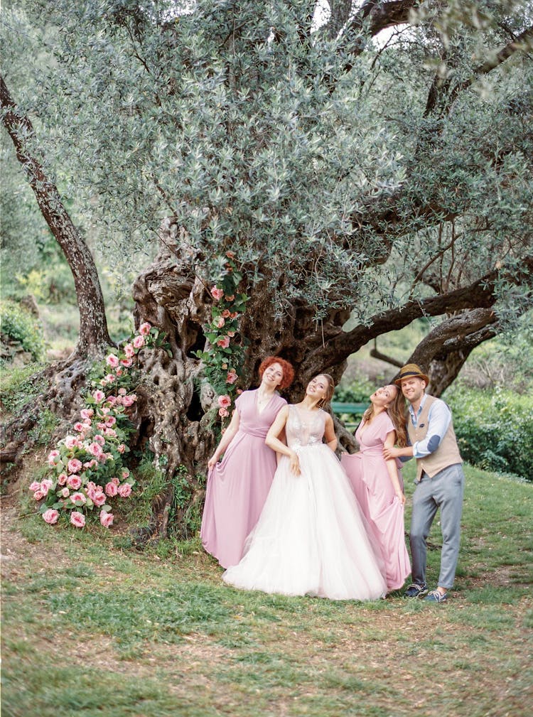 Bride And Bridesmaids Posing Near Old Tree