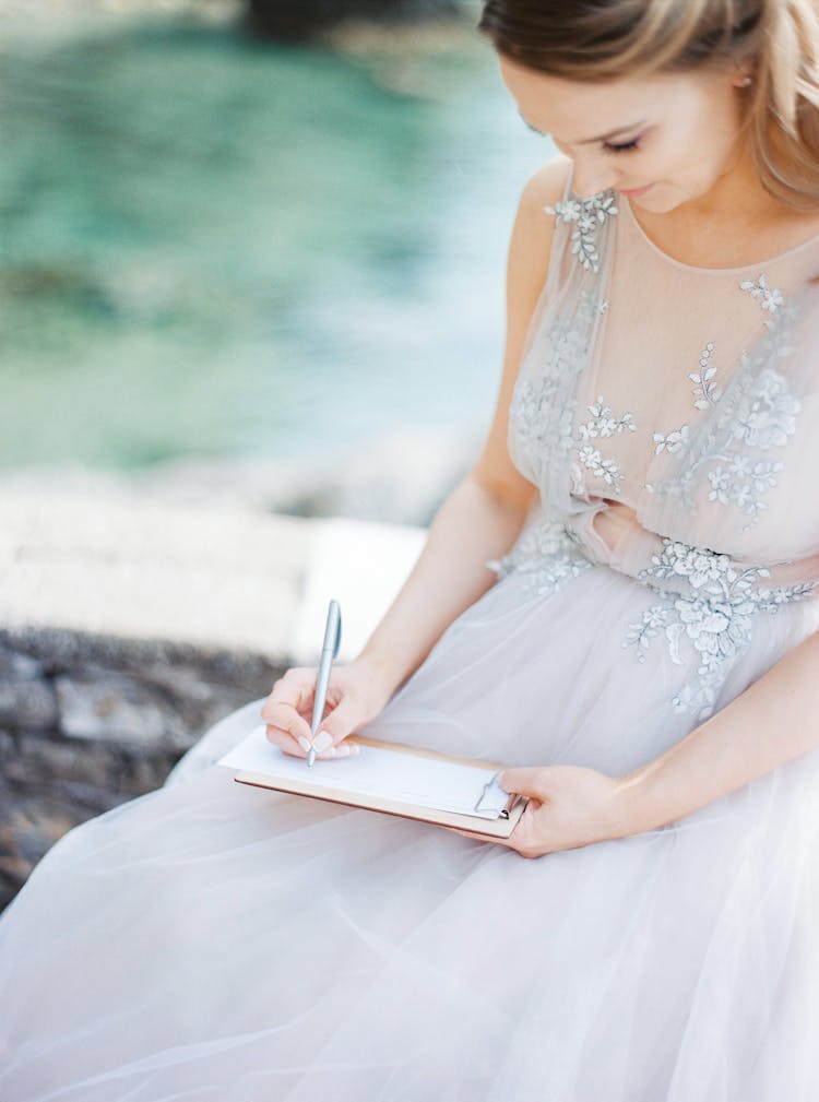 Bride In Wedding Dress Writing In Notepad 