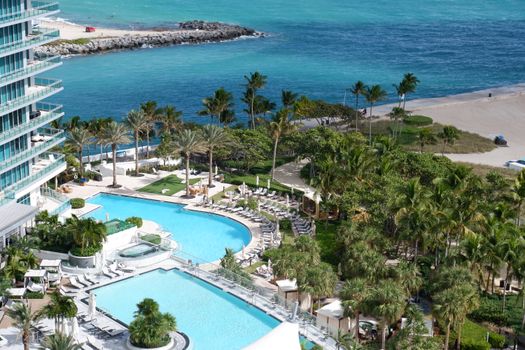 Lush Miami resort with pools and beachfront, offering a relaxing tropical escape.