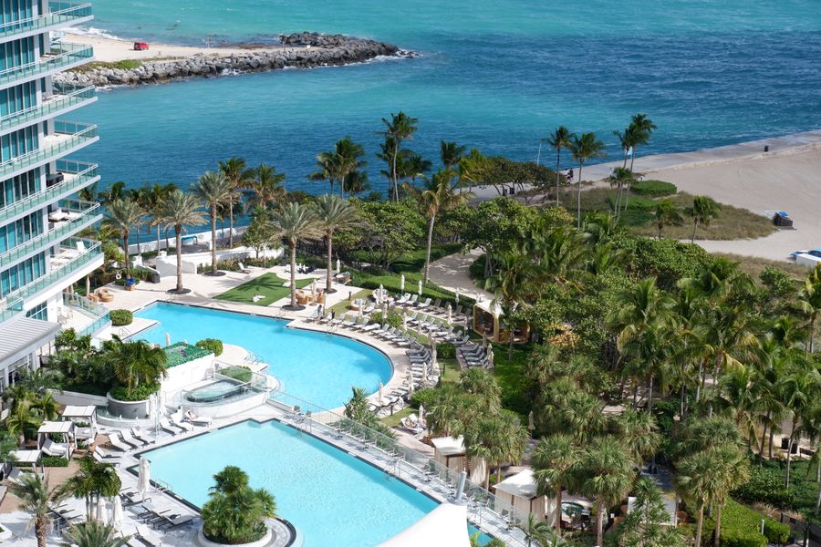 Luxury beachfront hotel with turquoise pools and palm trees overlooking Bal Harbour beach and ocean