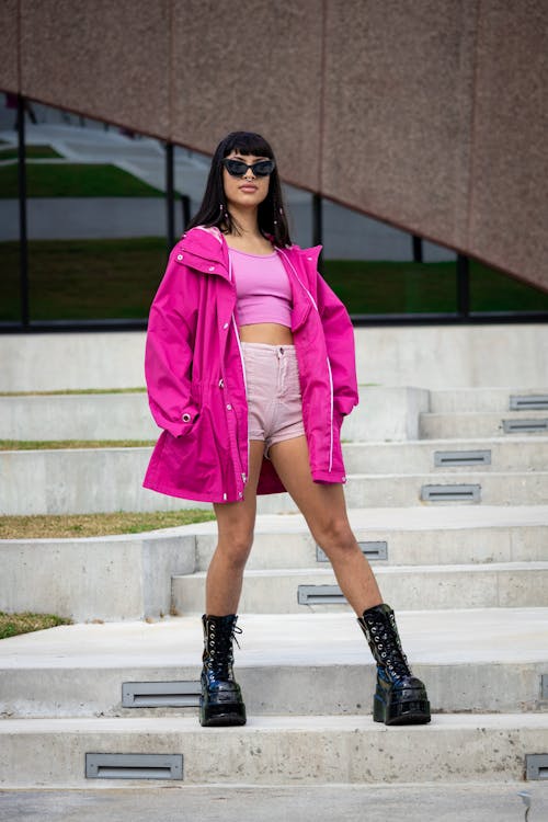 Beautiful Woman with Sunglasses in Pink Jacket Posing on Stairs