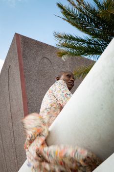 Stylish woman in a floral dress against modern architecture, reflecting elegance and joy.