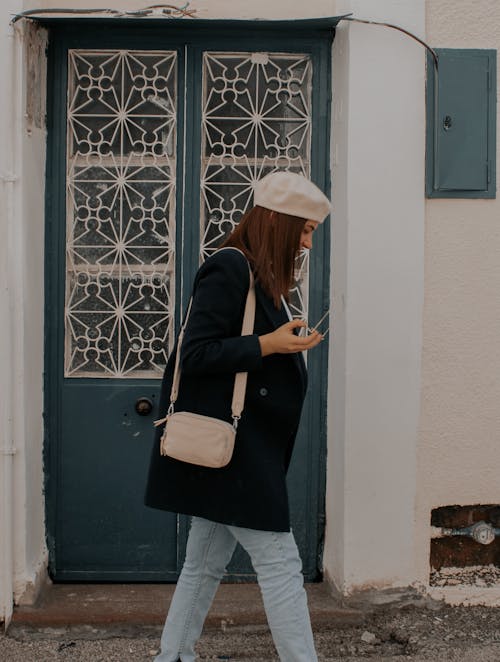 Foto profissional grátis de andando, blazer preto, bolsa carteiro