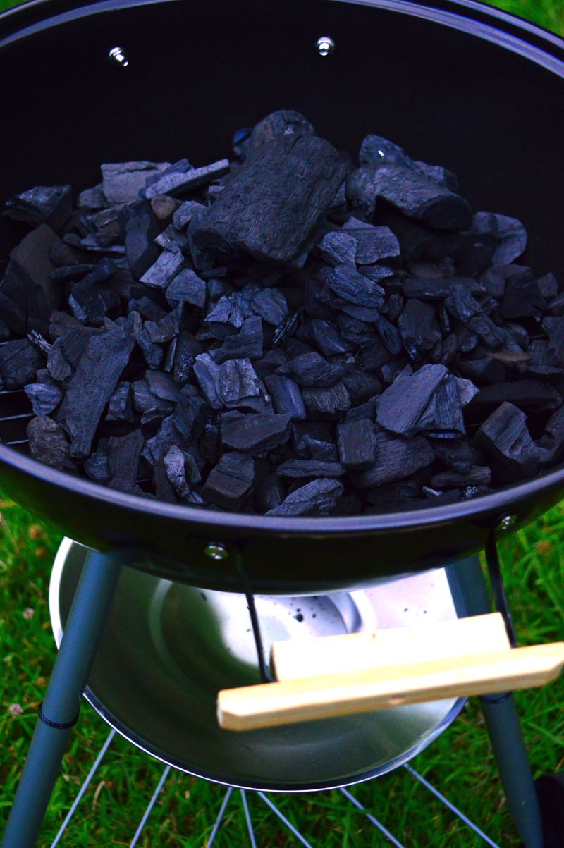 Grill mit Kohle und Fleisch bei einer Gartenparty