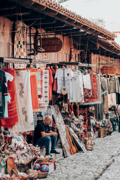 Free Explore the vibrant street market in Kruje, Albania featuring traditional textiles and souvenirs. Stock Photo