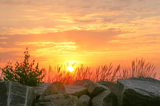Capture of a vibrant sunset over coastal rocks in Kühlungsborn, Germany.