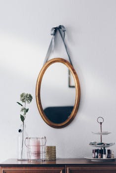 oval brown wooden framed hanging mirror
