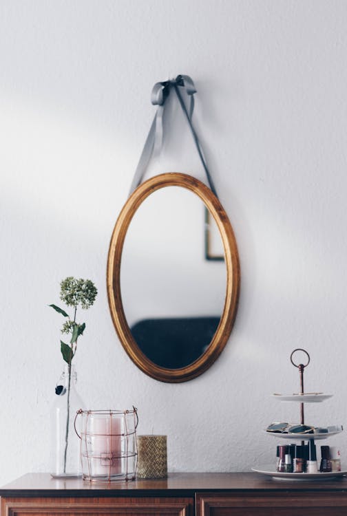 椭圆形棕色木制镜框挂镜