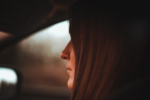 Free Side profile of a woman driving with a focus on her face in a car interior setting. Stock Photo