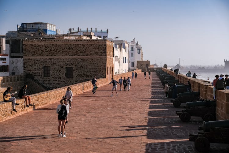 People Walking Near Cannons On Pavement