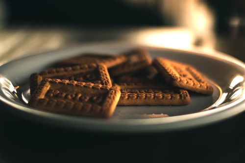 Free Close-up of square biscuits on a plate with warm lighting, perfect for snacks. Stock Photo