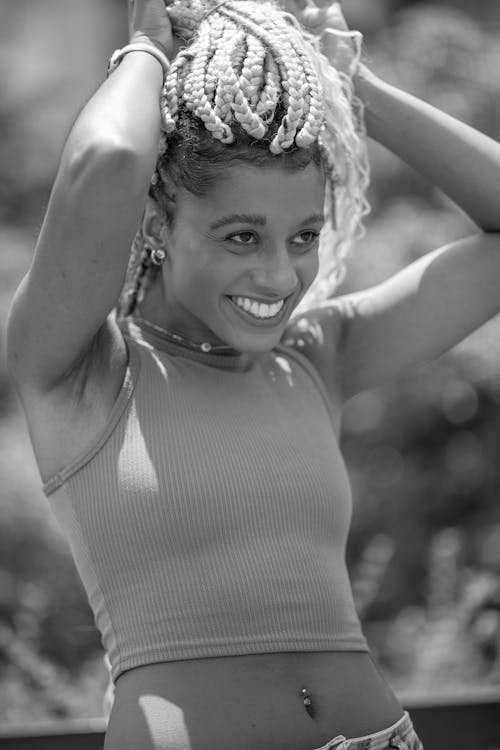 Smiling Woman Tying Her Braided Hair