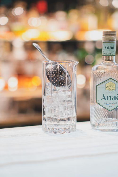 Free Elegant gin bottle next to a glass of ice cubes, perfect for cocktail hour inspiration. Stock Photo