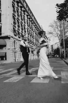 Newlyweds walk hand-in-hand on a street in Istanbul, Türkiye.