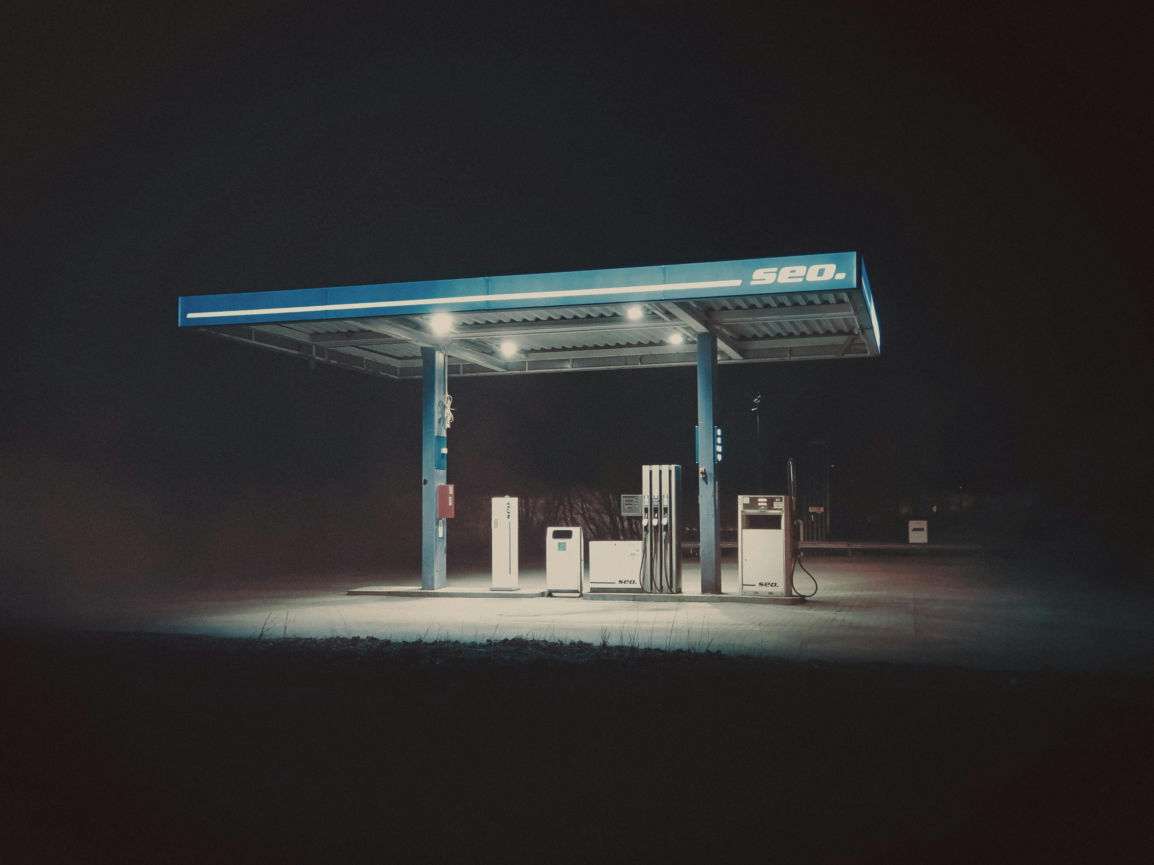 A gas station at night with a sign that says gas · Free Stock Photo
