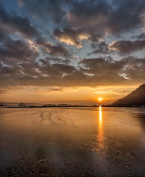 Serene winter sunset over a frozen lake in Minneiska, Minnesota.