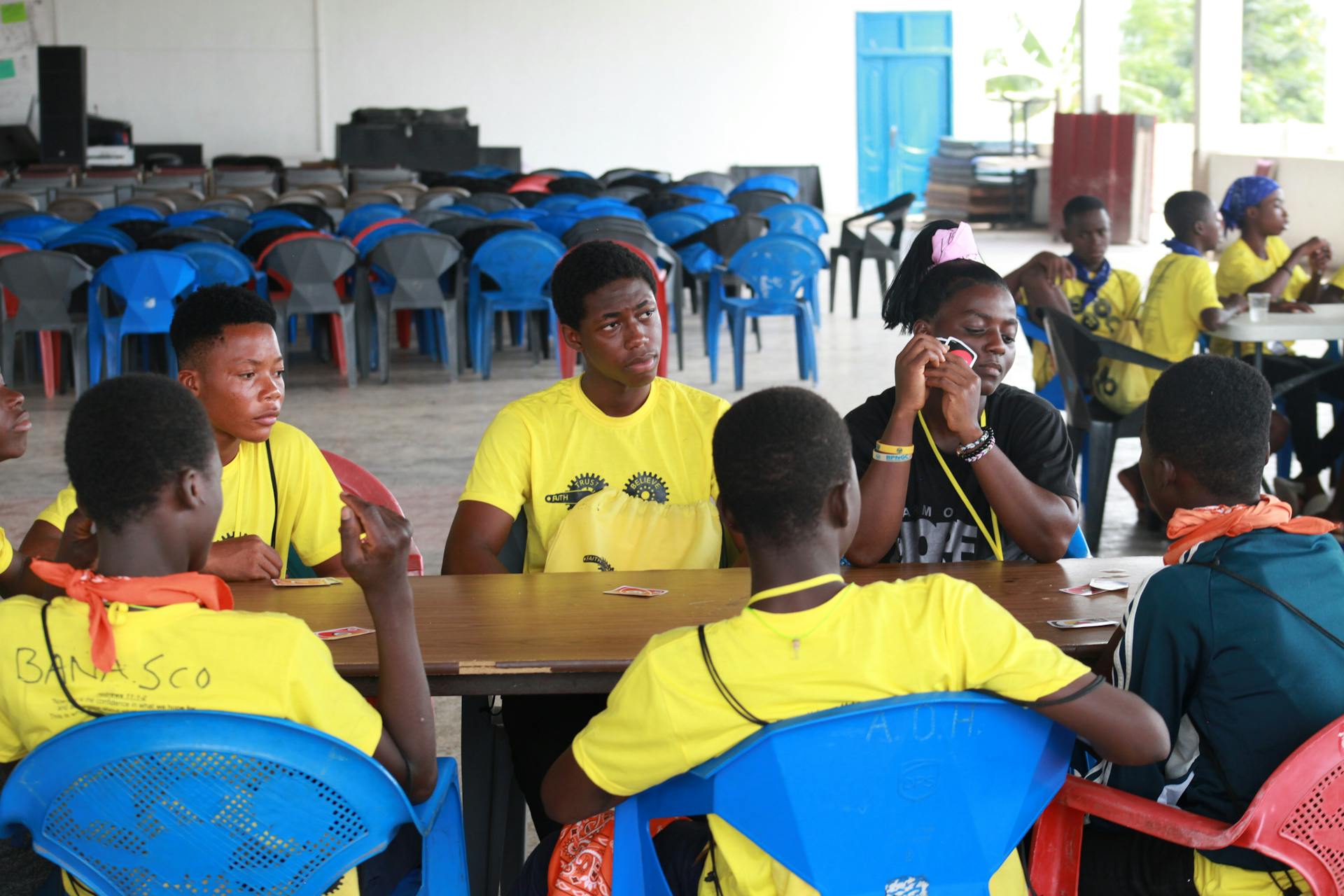 A group of teenagers enjoy playing cards indoors, conveying a sense of fun and relaxation.