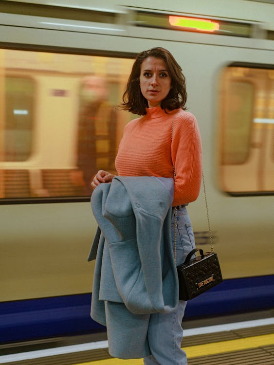 Woman in Orange Turtleneck Sweater With Black Shoulder Bag 