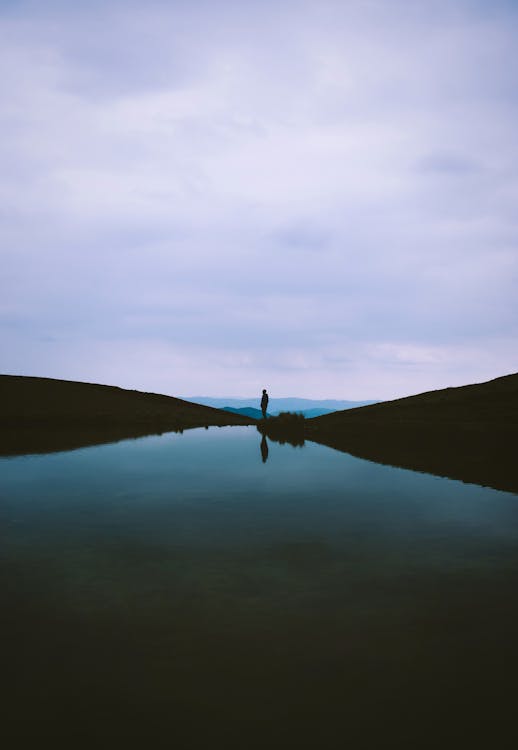 Silhouette of a Man and His Reflection in Water · Free Stock Photo