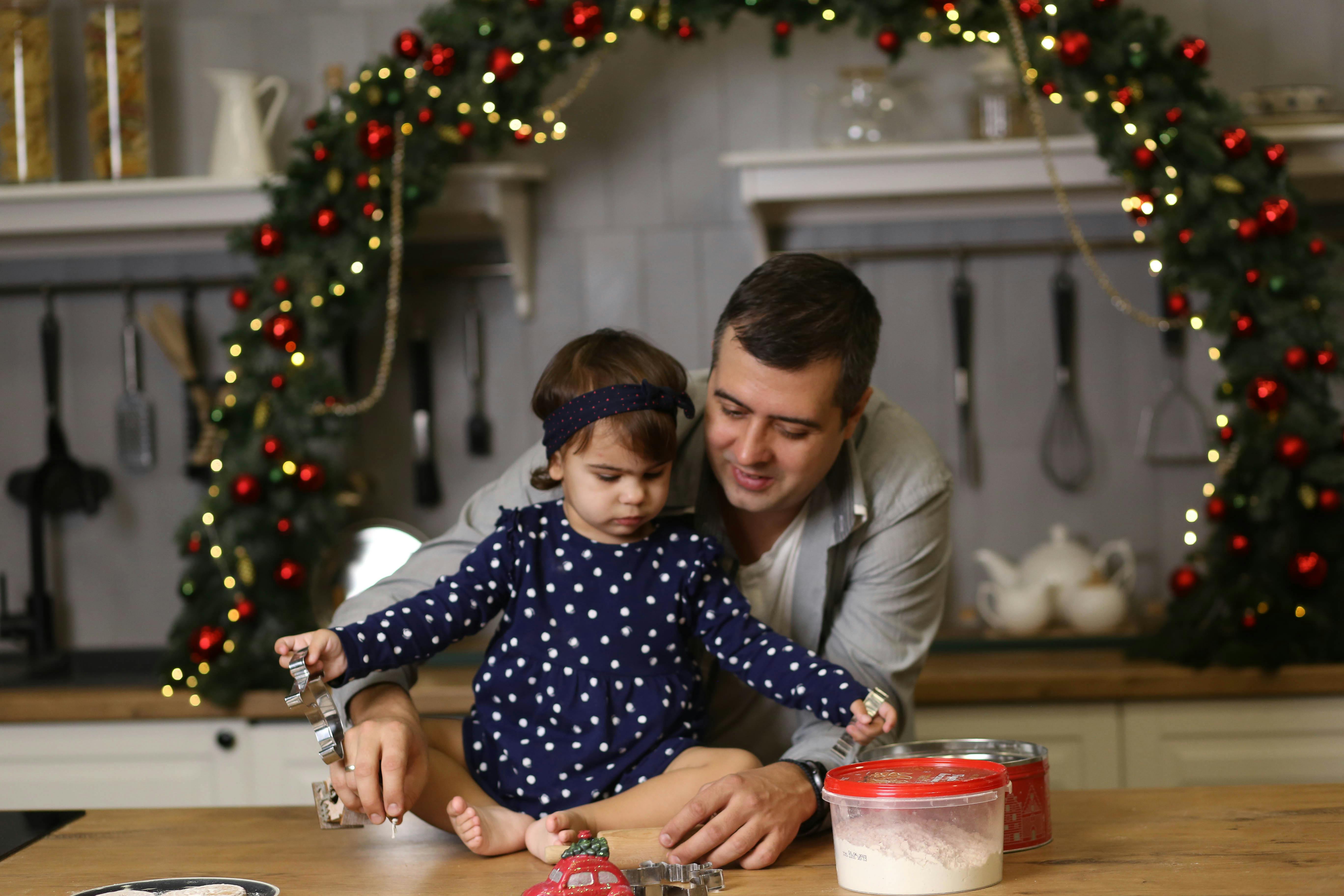 how to care for engraved gifts - A father and daughter baking together in a decorated kitchen, celebrating Christmas.
