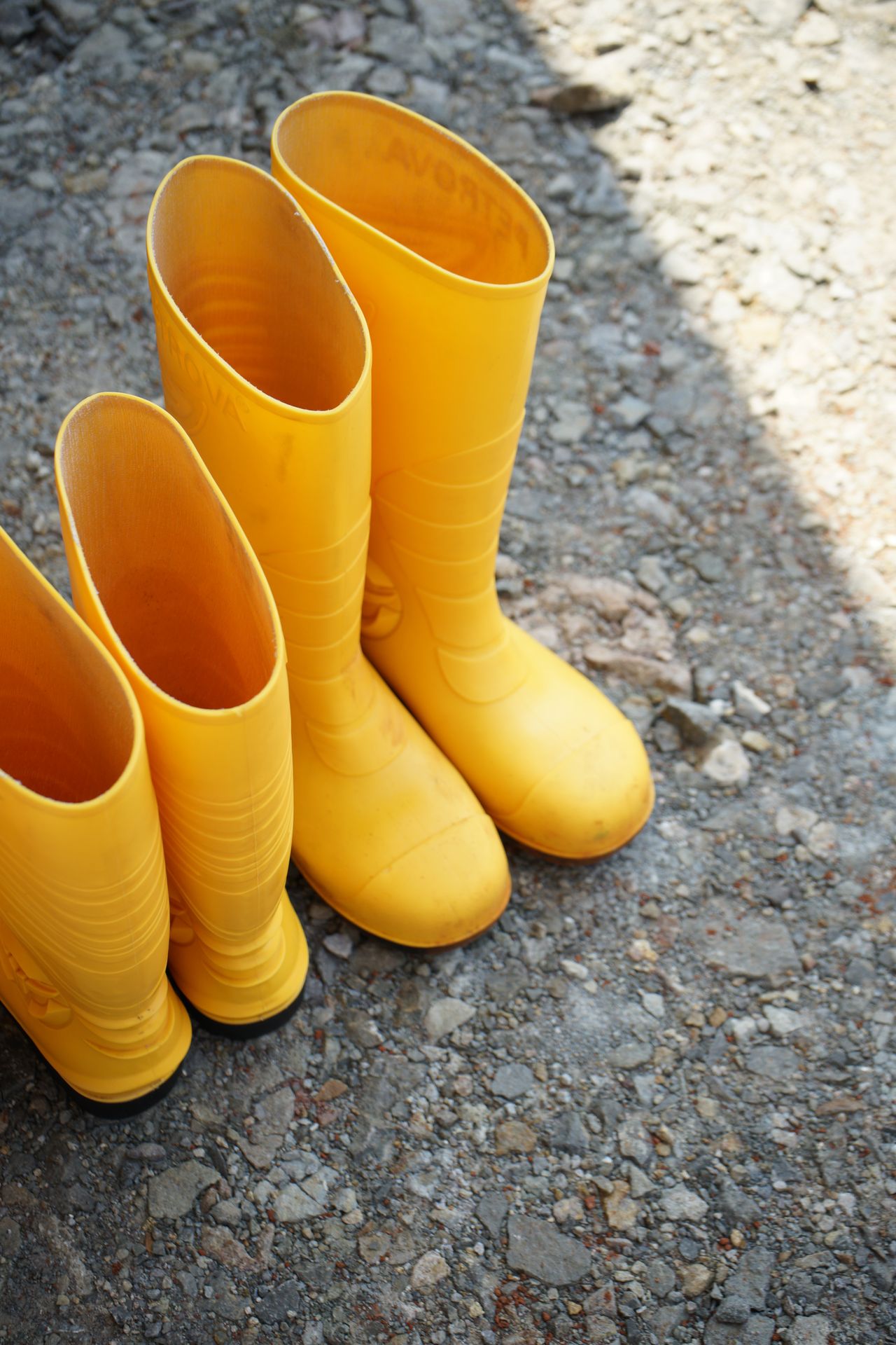 yellow rubber rain boots on rocky ground