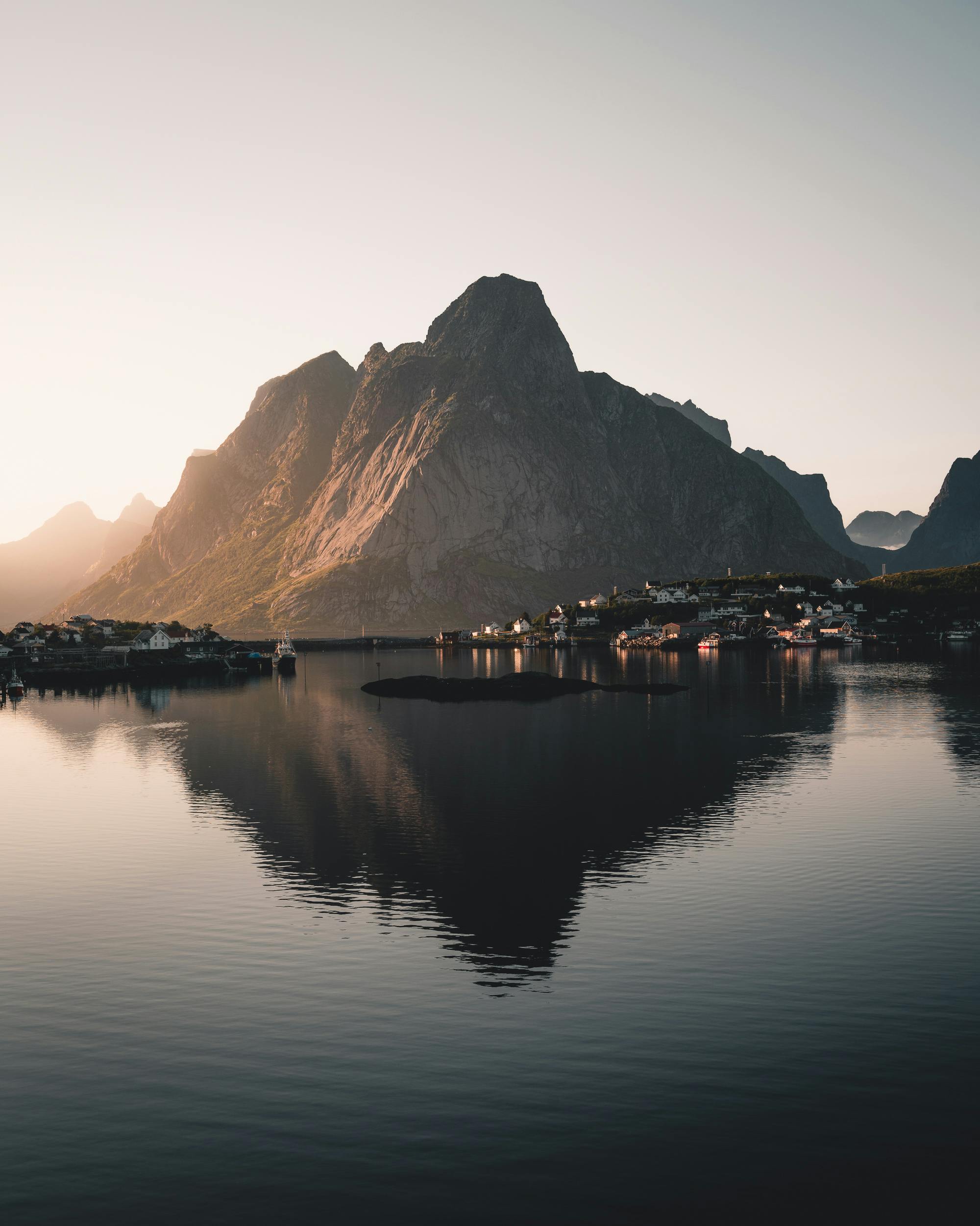 Breathtaking view of Nordland mountains reflecting in still waters at sunset, with serene natural beauty.