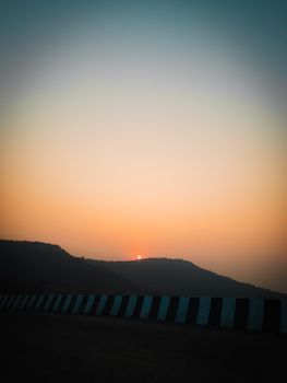 A breathtaking sunset with a silhouette of mountains and a clear sky.